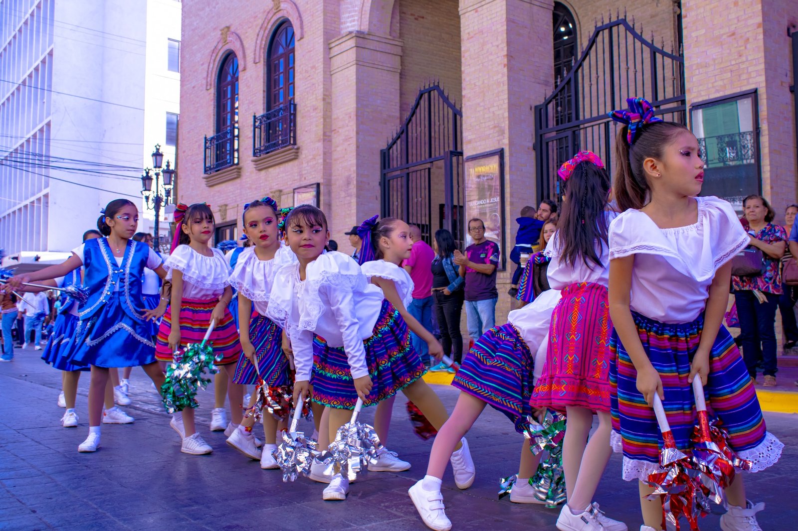 Alumnas del Colegio CEET marchando en el desfile cívico con trajes típicos.